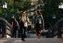 Two students walking on a bridge