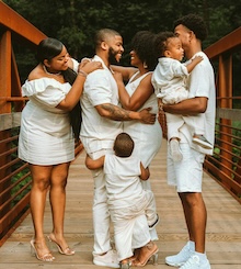 Six people smiling on a bridge